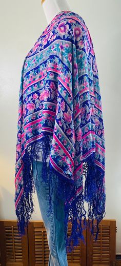 "Very Daisy Jones, here is a vintage shawl/scarf, purple with pink flowers and gray accents. Very delicate 100% pure silk with hand knotted purple fringe all around. Measures 36\" in diameter. PLEASE NOTE: This pretty vintage scarf does have some minor pinholes and one area where it has been mended, see photos. Still too beautiful to discard. Wear it as a wrap, drape it over a chair or table, many uses. Very cool." One Size Bohemian Scarf With Floral Print, Bohemian Scarves With Floral Print, One Size, Purple Silk Scarf With Floral Print For Spring, One Size Bohemian Scarves With Floral Print, Purple Floral Print Silk Scarf For Spring, Bohemian One-size Floral Print Scarves, Bohemian One Size Floral Print Scarves, Spring Bohemian Floral Print Dupatta, Bohemian Spring Floral Print Dupatta