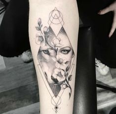 a woman's leg with a wolf and flowers tattoo on the side of her arm