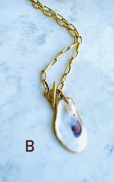 A truly One-of-a-Kind statement piece. Hand painted gold leaf natural oyster shell pendants with gorgeous freshwater pearls, on high quality 12K Gold over brass chain with toggle front closures. Each shell has been harvested in our Charleston, SC rivers and are carefully hand finished to create its one-of-a-kind appearance. No two shells are alike. Each oyster shell has its own story behind its journey to the shore. The size, shape and colors in each one will vary and that is what makes each she Handmade Shell Jewelry, Oyster Shell Necklace, Journey To The Shore, Oyster Ideas, Horse Unique, Ocean Jewelry, Oyster Shells, Shell Jewelry, Oyster Shell