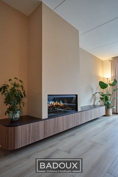 a large flat screen tv sitting on top of a wooden shelf in a living room