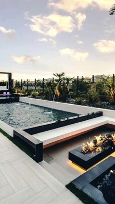 an outdoor living area with fire pit and water feature