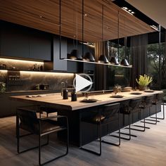 a large kitchen with black cabinets and wooden flooring, along with an island in the middle