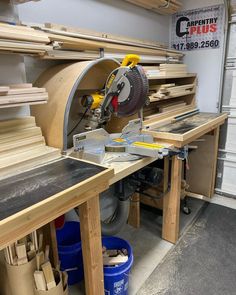 a table sawing on top of a piece of wood in a garage with other tools