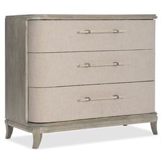 a white dresser with three drawers and two handles on the bottom drawer, against a white background