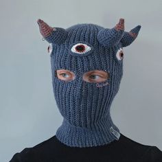 a man wearing a knitted mask with horns and eyes