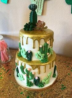 a three tiered cake with cactus decorations on the top and green frosting around it