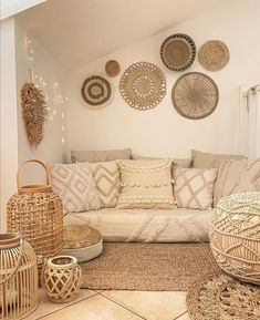 a living room filled with lots of wicker baskets on the wall next to a couch