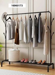 an iron rack with shoes and clothes hanging on the wall next to a potted plant