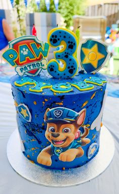 a blue birthday cake with paw patrol on it's top and the number three