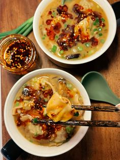 two bowls of soup with chopsticks on a wooden table next to each other