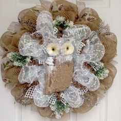 a burlock wreath with an owl on it hanging from the front door,