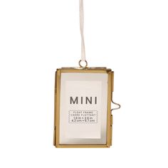 an ornament hanging from a string with the word mini in it's center