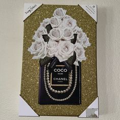 a chanel bag with flowers and pearls on the front is hanging from a wall