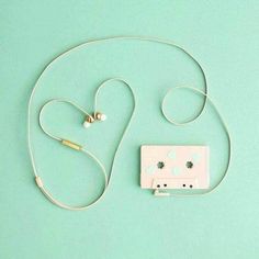 a cassette player and earphones on a green background with space for the word love