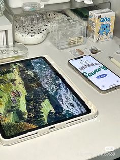 an ipad is sitting on a desk next to other items