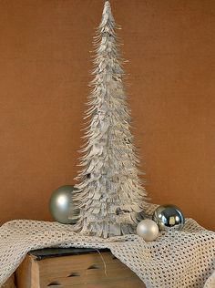 a small white christmas tree sitting on top of a wooden table next to a box