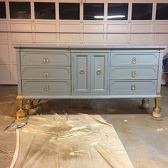 a large blue dresser sitting on top of a floor next to a pile of plastic