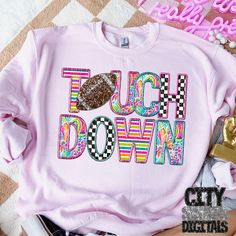 a pink sweatshirt with the words touch down on it and a donut in front