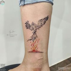 a woman's foot with a bird on it and fire coming out of the ground