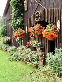 an old barn with flowers growing on the side