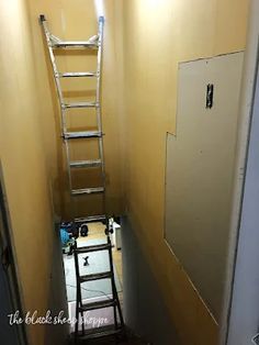 ladder leaning up against the wall in an empty room with yellow walls and white paint