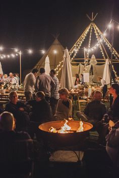 a group of people sitting around a fire pit