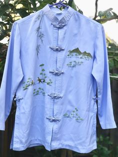 "Treat yourself or that special someone to this gorgeous light blue hand painted asian blouse with mandarin collar and frog closure asian shirt. Really pretty asian oriental blouse with long sleeve that appears to have minimum wear, very good, clean condition. Stylish woman silk blouse vintage top is great for all seasons. The chinese top woman shirt approximately measures when laying folded: from pit to pit- 19.5\" sleeve length-19\" length-24.5\" ( measuring from nap of neck to bottom edge down the back) Elegant asian clothes might be birthday gift for woman, silk women shirt for Valentines day gift for her, chinese blouse as an anniversary gift for wife, mandarin collar frog closure vintage silk top for Mother's day gift for mom, silk blouse for New Years or Christmas gift for women, as Formal Blouses For Women, Chinese Top, Chinese Blouse, Asian Clothes, Frog Closure, Light Blue Shirt, Daughter In Law Gifts, Woman Shirt, Unique Blouse