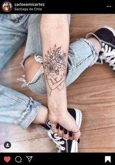 a woman's arm with flowers on it and her hand holding the wrist tattoo