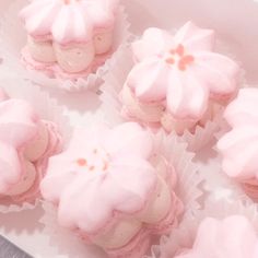 pink cupcakes with white frosting and flowers on them