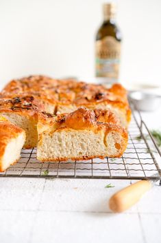 a loaf of bread sitting on top of a cooling rack next to a bottle of beer