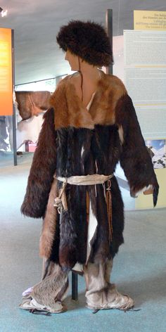 a woman in an animal costume standing next to a pole with fur on it's back