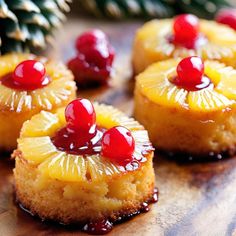 pineapple upside down cakes with cherries on top and pine cones in the background