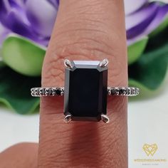 a woman's hand with a black diamond ring on it