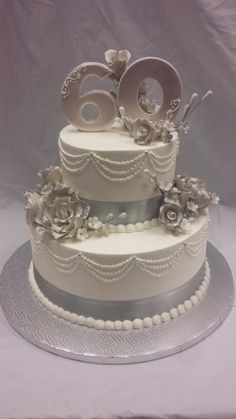 a three tiered cake with white frosting and flowers