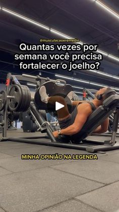 a man laying on top of a bench next to a barbell in a gym