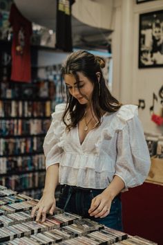 a woman is looking at cds in a store