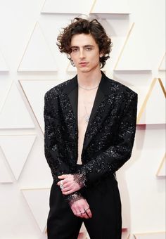 an image of a man in black suit on the oscars red carpet with his shirt open