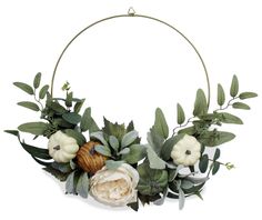 an arrangement of flowers and greenery arranged in a circle