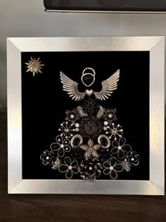 a black and silver christmas card with an angel on it