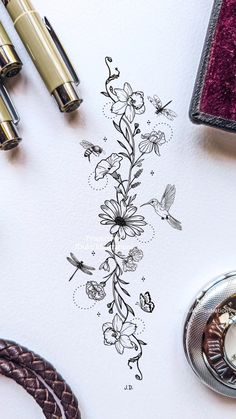 a drawing of flowers and butterflies on a piece of paper next to some writing utensils