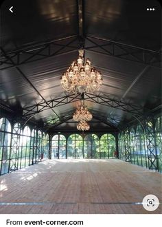 an empty room with chandelier and windows in the center for people to see