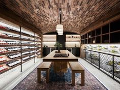 a wine cellar with rows of bottles on the wall and tables in front of it