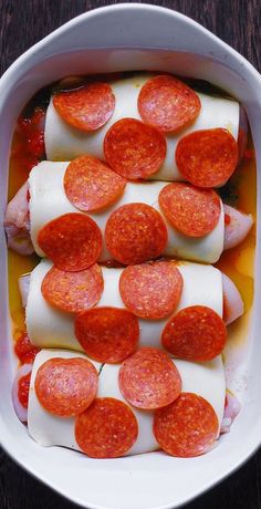 hotdogs and cheese in a white casserole dish on a wooden table