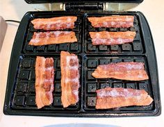 bacon is being cooked on an electric grill