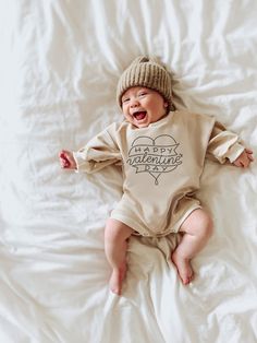 "Celebrate the day of love with this cozy cotton cream baby sweatshirt bubble romper featuring the text \" happy valentine day\". Makes a great baby shower gift, pregnancy announcement, or first valentines day outfit. This soft bodysuit is the perfect light sweatshirt material layer for baby. It is unisex in design, perfect for girl and boy adventurers alike! Item fits large and runs large as the style is oversized. The fit is a retro oversized width, styled to be relaxed and loungey. This produ White Long Sleeve Onesie Gift, Boys Valentines Outfit, Baby Valentines Outfit, First Valentines Day, Valentines Day Baby, Valentines For Boys, Valentines Outfits, Romper Outfit, Valentine's Day Outfit