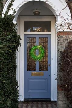 a blue front door with a green wreath on it