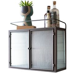 a metal cabinet with two glass doors and bottles on top is shown in front of a white background