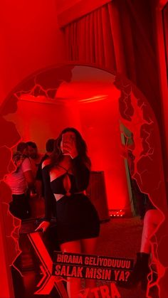 a woman standing in front of a mirror with red light on it's side