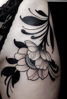 a woman's shoulder with black and white flowers on the left side of her arm