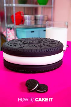 an oreo cookie sitting on top of a pink table